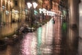 Late evening in the deserted city, lonely pedestrians rush home, rainy late evening. Bright illumination, reflection in Royalty Free Stock Photo