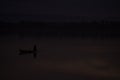 Late evening fishing canoe returning in nearly dark conditions showing decline of fish stocks in Asian rivers and lakes due to Royalty Free Stock Photo