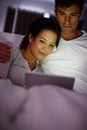 Late night movie date. a couple watching movies on a digital tablet while sitting in bed. Royalty Free Stock Photo