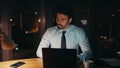 Late office worker sitting dark workplace with laptop closeup. Businessman tired Royalty Free Stock Photo