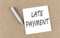 LATE PAYMENT text on sticky note on a cork board with pencil Royalty Free Stock Photo