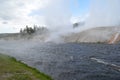 Late Spring in Yellowstone National Park: Steam Rolls Off Excelsior Geyser Crater Next to Firehole River in Midway Geyser Basin Royalty Free Stock Photo