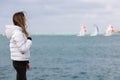 Late teen girl observing yacht regatta in windy day Royalty Free Stock Photo