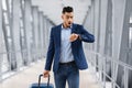 Late To Flight. Worried Arab Man Checking Time On Wristwatch At Airport