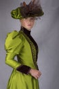 Late Victorian woman in green silk ensemble