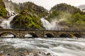 Latefoss twin waterfalls streams under the stone bridge archs, Odda, Hordaland county, Norway