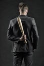 Latent aggression. Man with bat hides his aggression slow down and keep calm, rear view. Businessman or man in formal