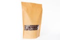 Lateral view of brown paper doypack stand up pouch with window zipper filled with coffee beans on white background Royalty Free Stock Photo