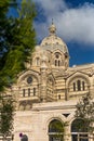 Lateral view of Marseilles\' Cathedral in the afternoon with some clouds in the blue sky . Cathedrale