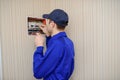 Young electrician in blue overall disassembling a electrical panel with fuses in a house