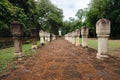 Laterite stone paved walkway with free-standing stone posts to the gates of ancient Khmer temple built of red sandstone and lateri