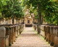 Laterite stone paved walkway with free-standing stone posts to the gates of ancient Khmer temple built of red sandstone and lateri