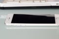 Latest iPhone on desk in horizontal frame with blurred laptop PC keyboard