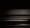 Lathe part - a feeder rod with a thread on a dark background Royalty Free Stock Photo