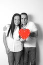 Latin adult couple in black and white show their love by toasting with red glasses for the arrival of February and celebrate Valen Royalty Free Stock Photo