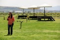 Latin adult woman with hat walking with her mobil in vineyard with umbrellas and stepped on grapes for harvest outdoors