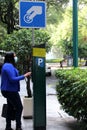 Latin adult woman with protection mask paying public parking on the street, new normal covid-19 Royalty Free Stock Photo