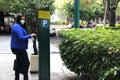 Latin adult woman with protection mask paying public parking on the street, new normal covid-19 Royalty Free Stock Photo