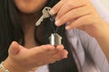 Latin adult woman shows the keys to her new home on a house-shaped keychain, feels successful and proud of her achievement Royalty Free Stock Photo
