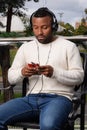 Latin afro-descendant man listening to music on his cell phone