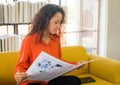 Latin America woman reading newspaper on sofa Royalty Free Stock Photo