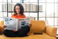 Latin America woman reading newspaper on sofa Royalty Free Stock Photo