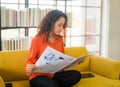 Latin America woman reading newspaper on sofa Royalty Free Stock Photo