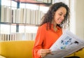 Latin America woman reading newspaper on sofa Royalty Free Stock Photo