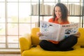 Latin America woman reading newspaper on sofa Royalty Free Stock Photo