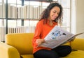 Latin America woman reading newspaper on sofa Royalty Free Stock Photo