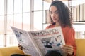 Latin America woman reading newspaper on sofa Royalty Free Stock Photo