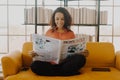 Latin America woman reading newspaper on sofa Royalty Free Stock Photo