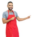 Latin american clerk or waiter or chef with red apron pointing sideways Royalty Free Stock Photo