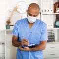 Portrait of friendly male doctor or nurse wearing blue scrubs uniform and stethoscope Royalty Free Stock Photo