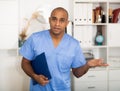Portrait of friendly male doctor or nurse wearing blue scrubs uniform and stethoscope Royalty Free Stock Photo