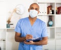 Portrait of friendly male doctor or nurse wearing blue scrubs uniform and stethoscope Royalty Free Stock Photo