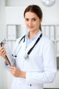 Latin american doctor woman standing with arms crossed and smiling at hospital. Physician ready to examine patient Royalty Free Stock Photo