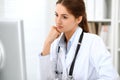 Latin american doctor woman standing with arms crossed and smiling at hospital. Physician ready to examine patient Royalty Free Stock Photo