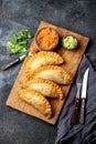 Latin American fried empanadas with tomato and avocado sauces. Top view