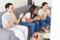 Latin American friends watching sports on television at home Royalty Free Stock Photo