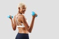 Latin American happy smiling woman lifts dumbbells, young female athlete doing fitness workout, engaged in physical activity to Royalty Free Stock Photo