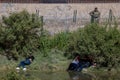 Latin American migrants hiding from National Guard while attempting to cross border from Mexico Royalty Free Stock Photo