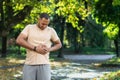 Latin american runner sportsman has severe stomach pain, man holding hand on side of stomach after doing exercise and