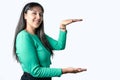 Young woman holding something on her hands and looking at the camera over white background Royalty Free Stock Photo