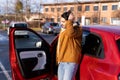 Latin or arab man standing near car with opened door on parking slot of city