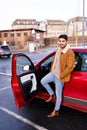 Latin or arab man standing near car with opened door on parking slot of city