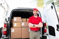 Smiling delivery courier and driver standing next to a truck Royalty Free Stock Photo