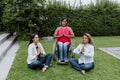 Latin business woman transgender on wheels chair and friends sitting on grass and meditating at terrace office in Mexico Latin Ame