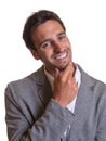 Latin businessman in grey suit laughing at camera