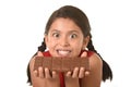 Latin child in red dress holding with both hands big chocolate bar in front of her crazy excited face expression Royalty Free Stock Photo